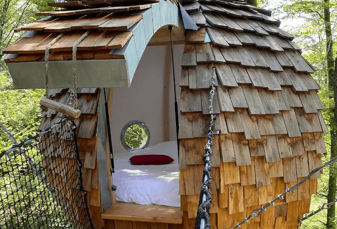 This picture is showing a beautiful woody cabin with a mattress which is representing Airbnb Unique Experiences